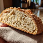 Close-up of a slice of sourdough bread made with active sourdough starter recipes, showing the airy crumb structure.