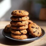A stack of freshly baked Air Fryer Cookies with melted chocolate chips on a plate, ready to eat.