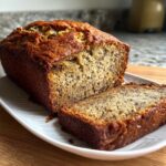 A loaf of freshly baked banana bread with a slice cut out, perfect wedding shower food.