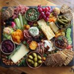 Overhead shot of a beautiful charcuterie board, perfect bridal shower food, with cheeses, meats, fruits, and crackers.