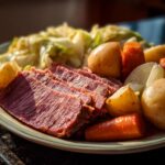 A plate of delicious corn beef and cabbage recipe with sliced corned beef, cabbage, potatoes, and carrots.