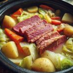 A pot of Grandma's corned beef and cabbage, featuring sliced corned beef, cabbage, carrots, and potatoes.