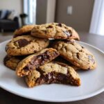 A stack of delicious cottage cheese chocolate chip cookies, one broken in half to show the melted chocolate inside.