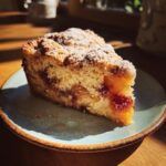 A slice of Crock Pot Dump Cake on a plate, showcasing the cake, fruit filling, and powdered sugar topping.