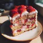 A delicious slice of layered strawberry cake, showcasing fresh strawberries and cream filling. Perfect for fresh strawberry recipes.