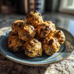 A stack of homemade protein balls with oats and chocolate chips on a blue plate, ready to eat.