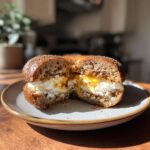 A sliced protein bagel with greek yogurt filling, showcasing the creamy texture and deliciousness.