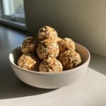 A bowl filled with homemade protein balls with protein powder, coated in oats.