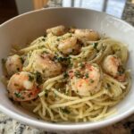 A bowl of shrimp recipes pasta, featuring perfectly cooked shrimp, spaghetti, herbs, and a light sauce.