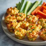 Plate of veggie bites, a healthy game day finger foods option, served with carrot and cucumber sticks.