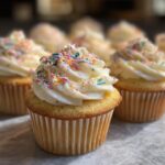 Close-up of wildflower cupcakes with white frosting and colorful sprinkles. Perfect for a party!