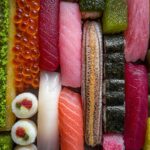 Close-up of a colorful candy sushi board with various types of candy arranged to resemble sushi.